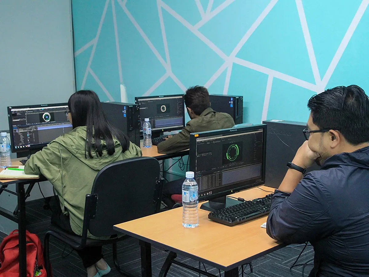 Participants working on After Effects at desktop workstations