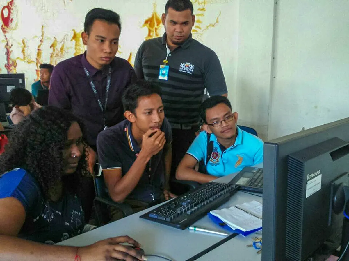 Participants collaborating around a computer screen